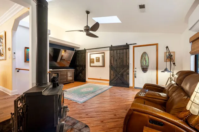 a kitchen with stainless steel appliances granite countertop a refrigerator a microwave a stove and a dining table with wooden floor