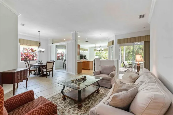 a view of a dining room with furniture a chandelier and wooden floor