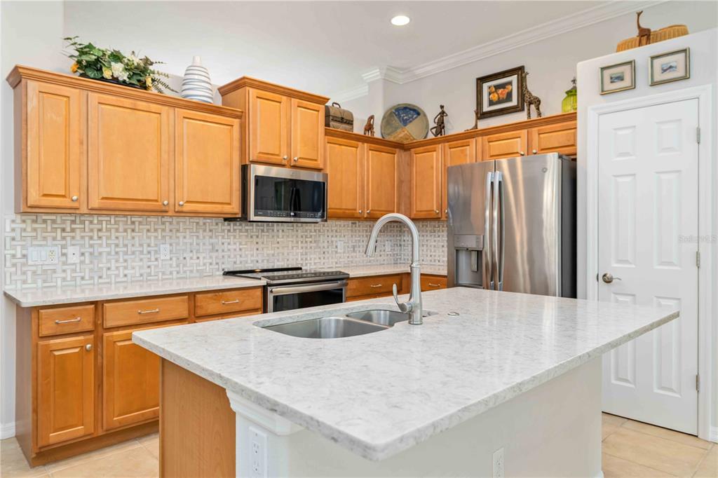 8150 Indigo Ridge Terrace University Park, FL 34201 - Photo 21 of 56 a kitchen with stainless steel appliances granite countertop a sink a refrigerator and a granite counter tops with white cabinets