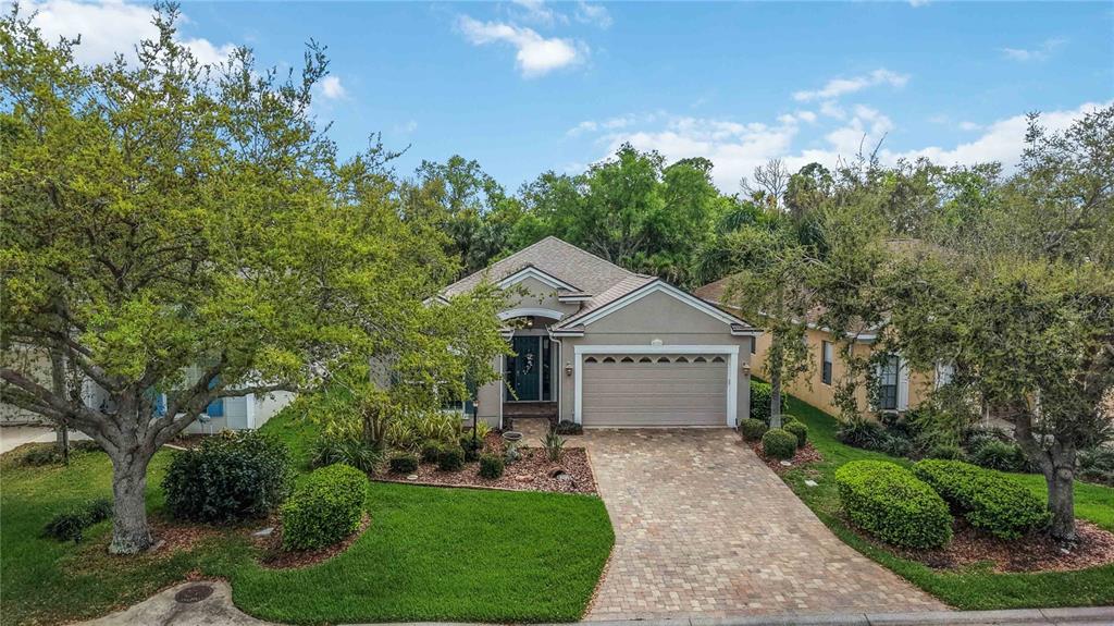 8150 Indigo Ridge Terrace University Park, FL 34201 - Photo 38 of 56 a front view of a house with a garden and trees