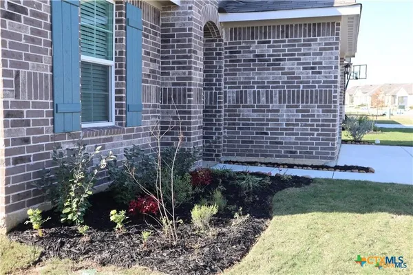 a view of a brick house with a yard