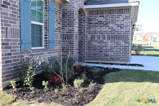 a view of a brick house with a yard