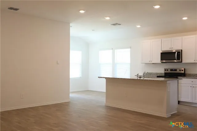 a kitchen with stainless steel appliances a refrigerator and a stove top oven