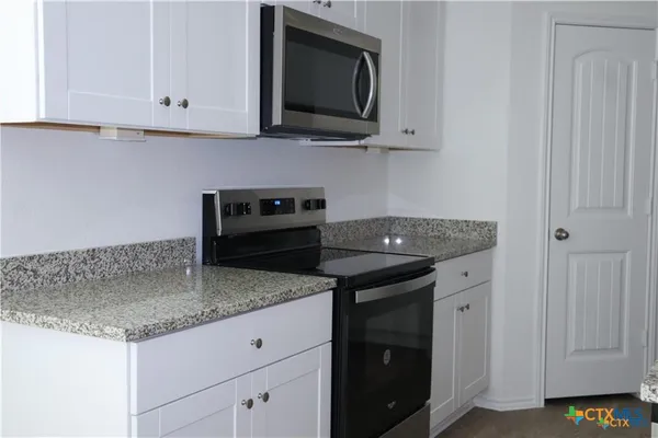 a kitchen with granite countertop a sink and a stove
