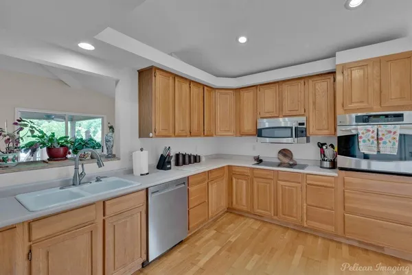 a kitchen with stainless steel appliances granite countertop a sink stove and cabinets