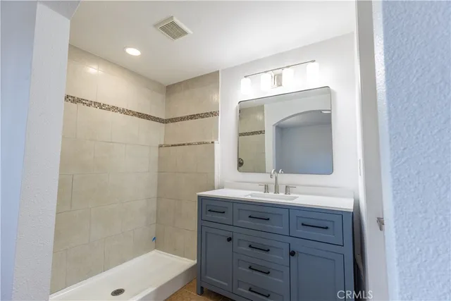 a bathroom with a sink shower and a mirror