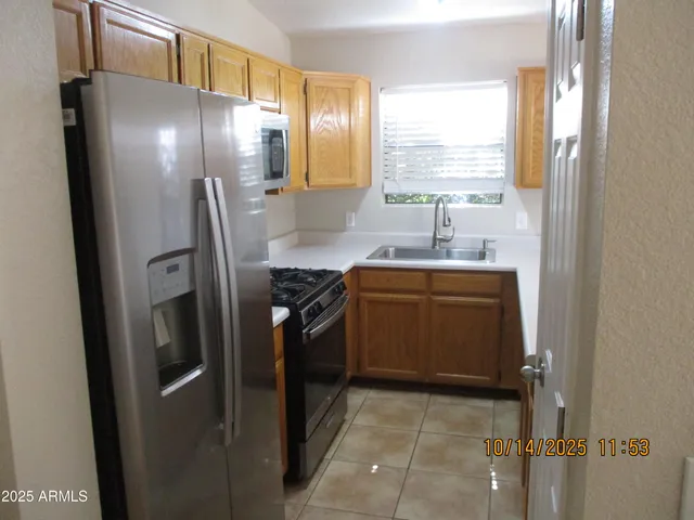 a kitchen with stainless steel appliances a refrigerator sink and stove