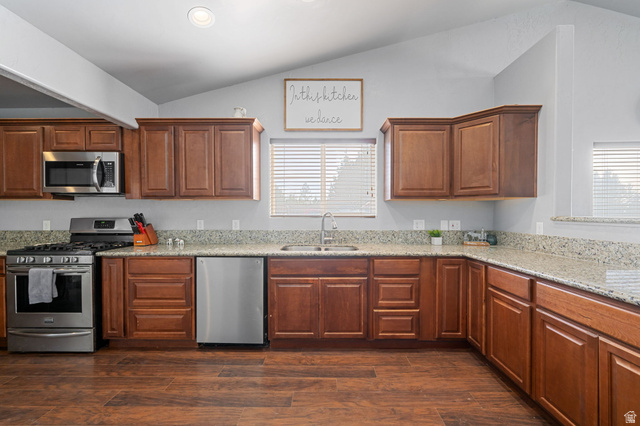 348 North Lodge Road Central, UT 84722 - Photo 23 of 25 Kitchen with stainless steel appliances, wood finish cabinets, light stone counters, dark wood-style flooring, and vaulted ceiling