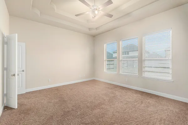 an empty room with windows and fan