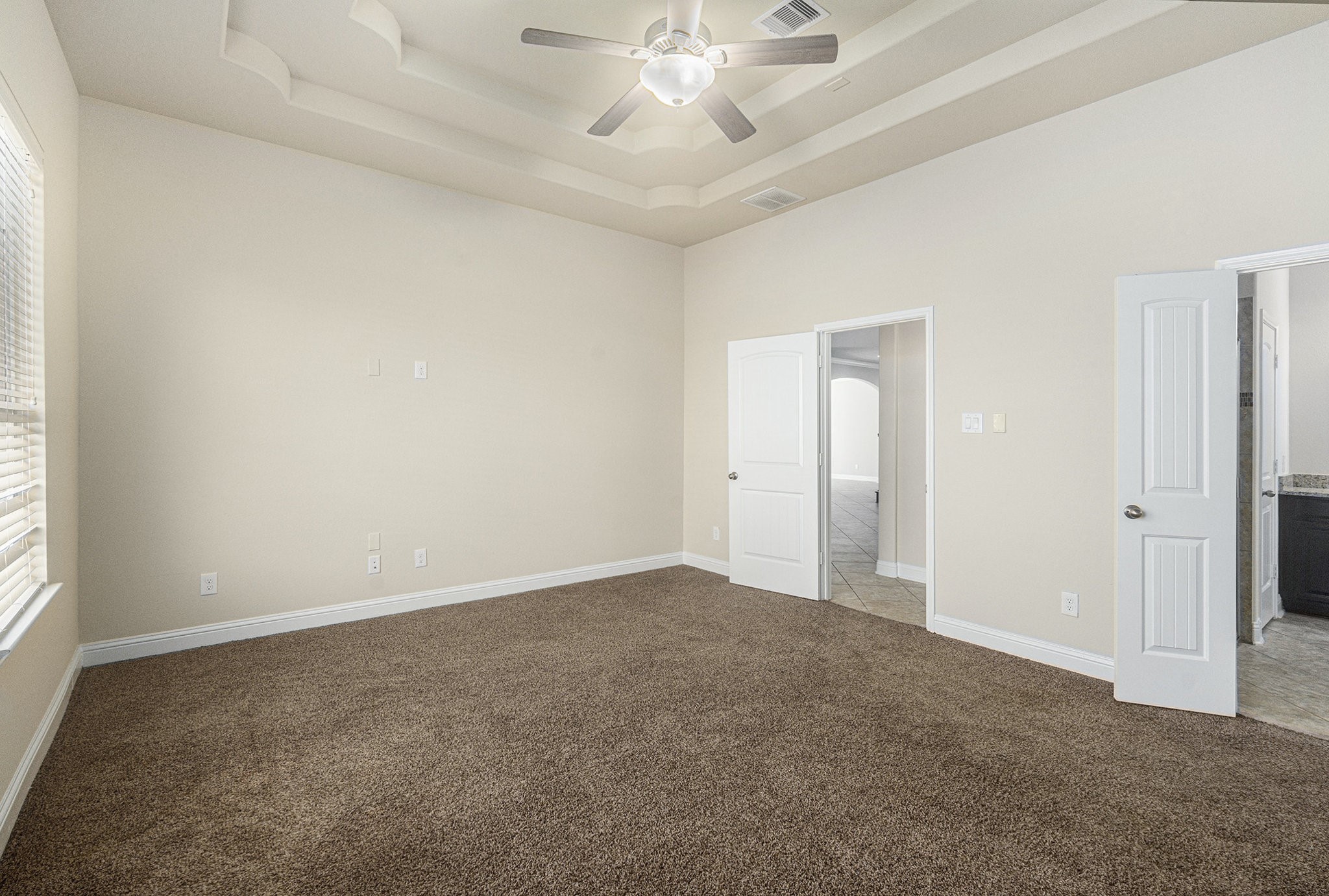 18614 Rimini Ridge Court Cypress, TX 77429 - Photo 14 of 35 an empty room with a chandelier fan and windows