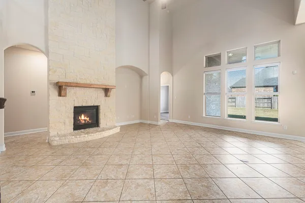 a view of an empty room with a fireplace and a window