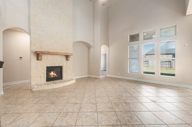 a view of an empty room with a fireplace and a window