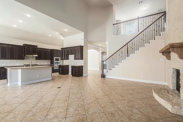 a view of kitchen with stainless steel appliances kitchen island granite countertop a sink and cabinets