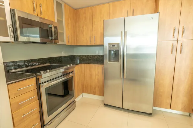 a metallic refrigerator freezer sitting in a kitchen