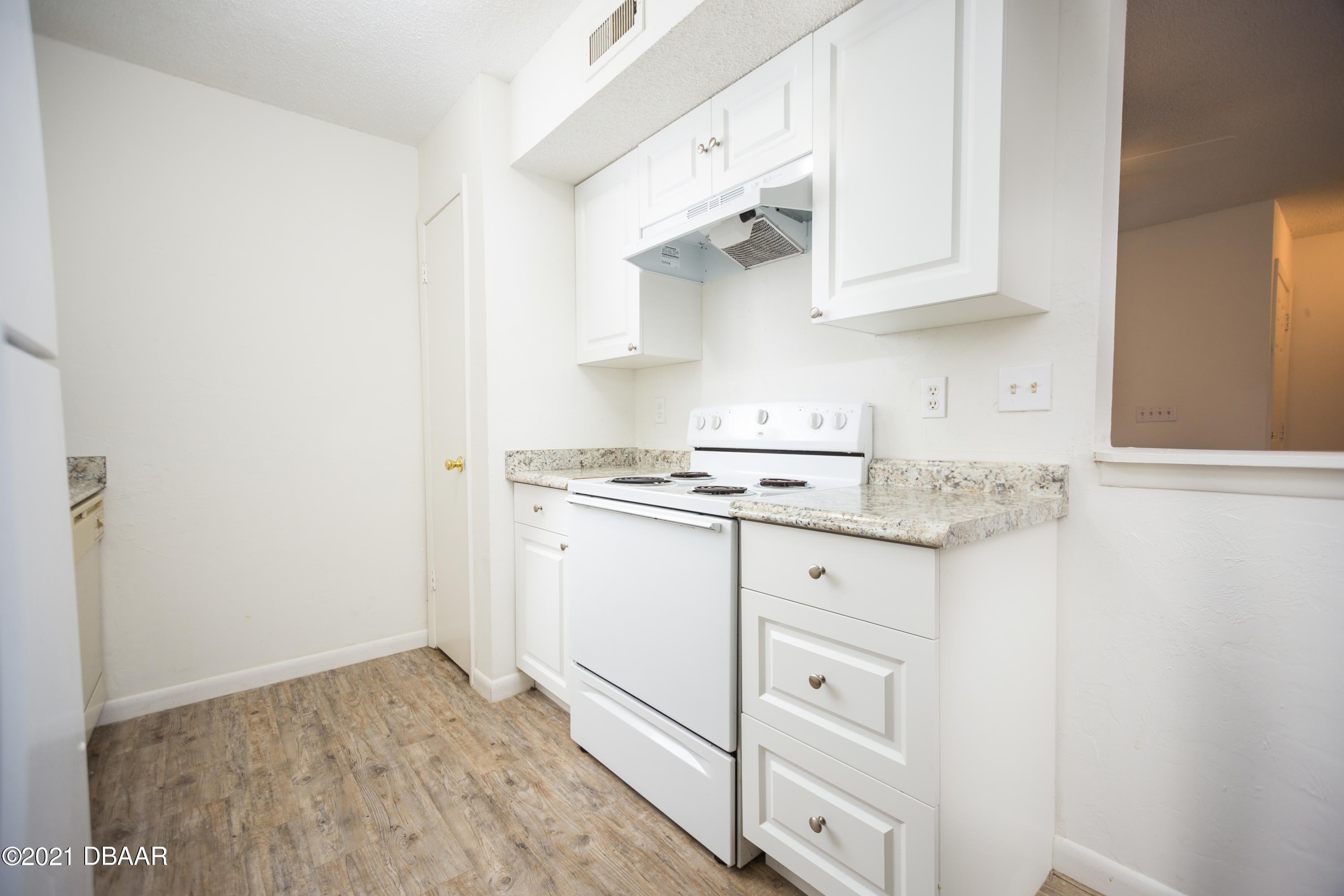 1600 Big Tree Road, Unit B8 South Daytona, FL 32119 - Photo 15 of 27 a kitchen with white cabinets and white appliances