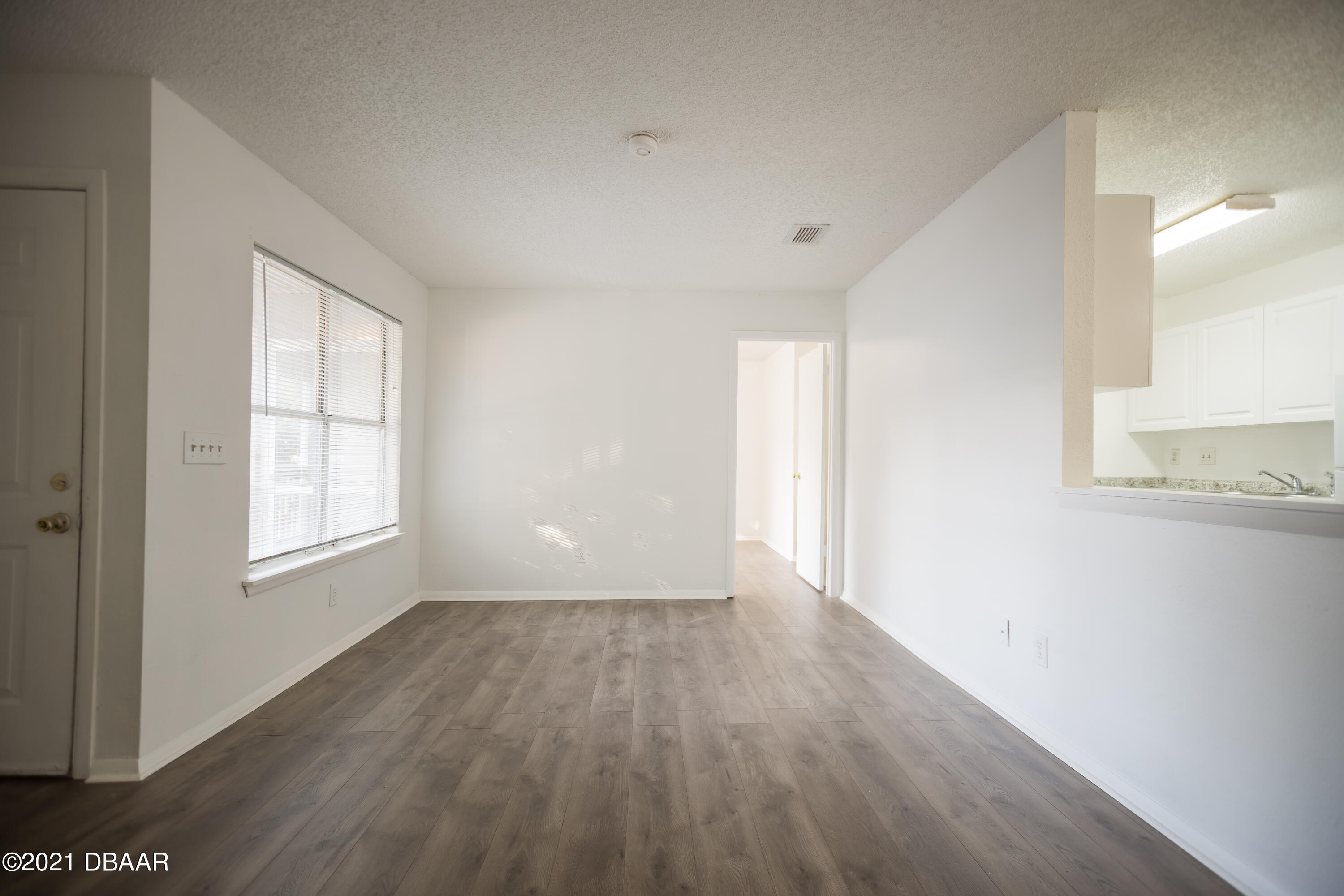 1600 Big Tree Road, Unit B8 South Daytona, FL 32119 - Photo 9 of 27 a view of an empty room with wooden floor and a window