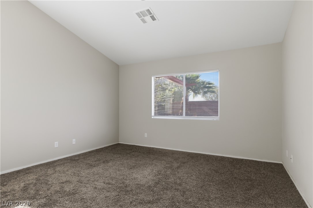 5100 Rancher Avenue Las Vegas, NV 89108 - Photo 9 of 26 A spacious chamber awaits personalization, complete with abundant natural light from a broad window and a plush, comforting carpet.