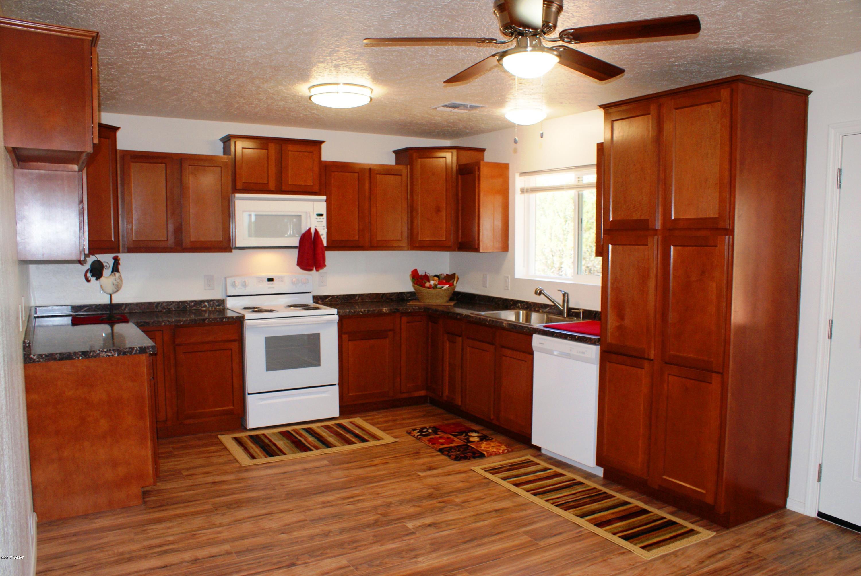 2628 Elk Run Loop Show Low, AZ 85901 - Photo 7 of 26 a kitchen with granite countertop wooden cabinets and white appliances