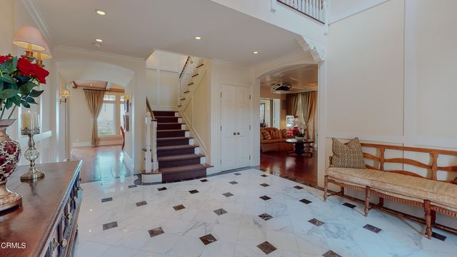 a dining room with stainless steel appliances kitchen island granite countertop a dining table chairs and a refrigerator