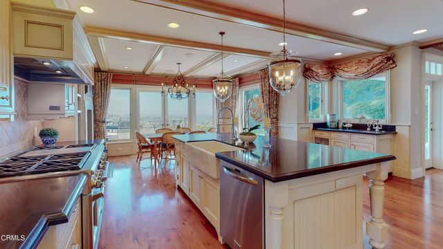 a view of a dining room and livingroom with furniture wooden floor a chandelier