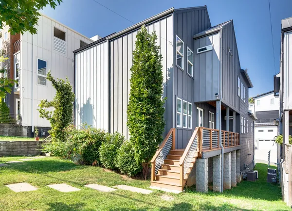 a view of house with yard and deck