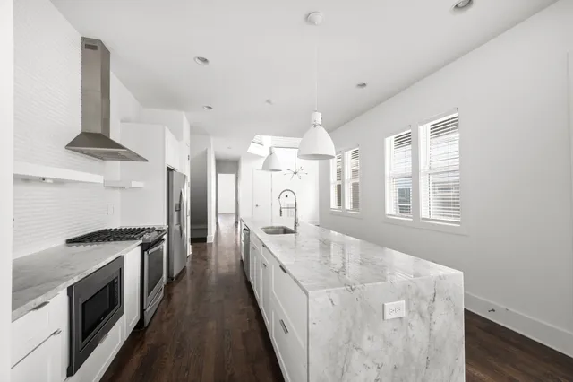 a large white kitchen with a stove top oven