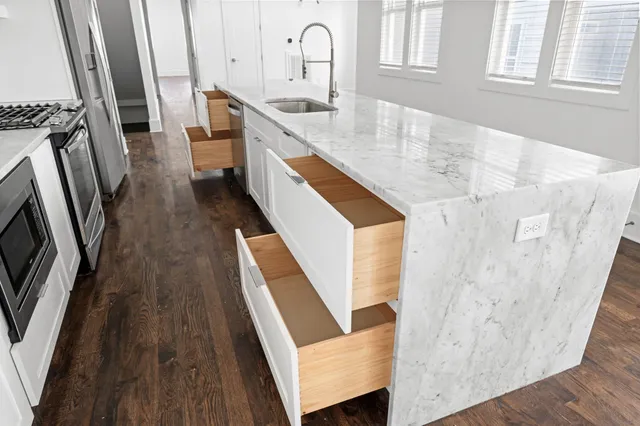 a kitchen with sink a refrigerator and wooden floor