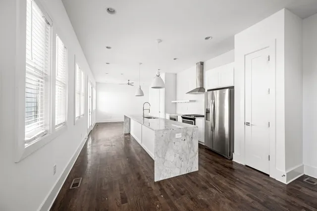 a view of a kitchen with wooden floor and stainless steel appliances