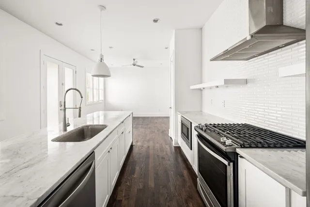a kitchen with sink stove and cabinets