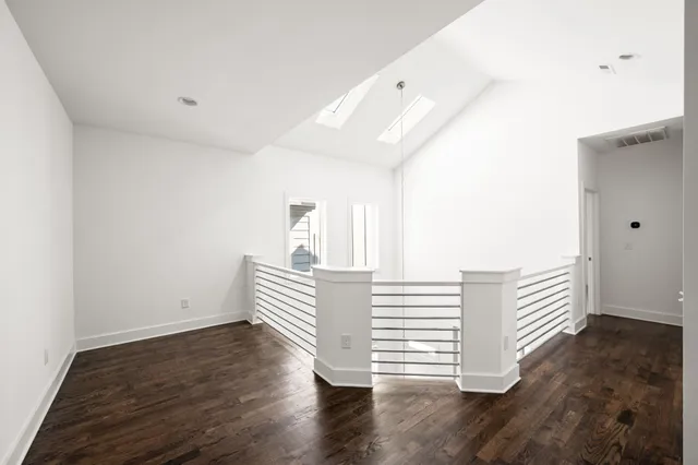 a view of empty room with wooden floor