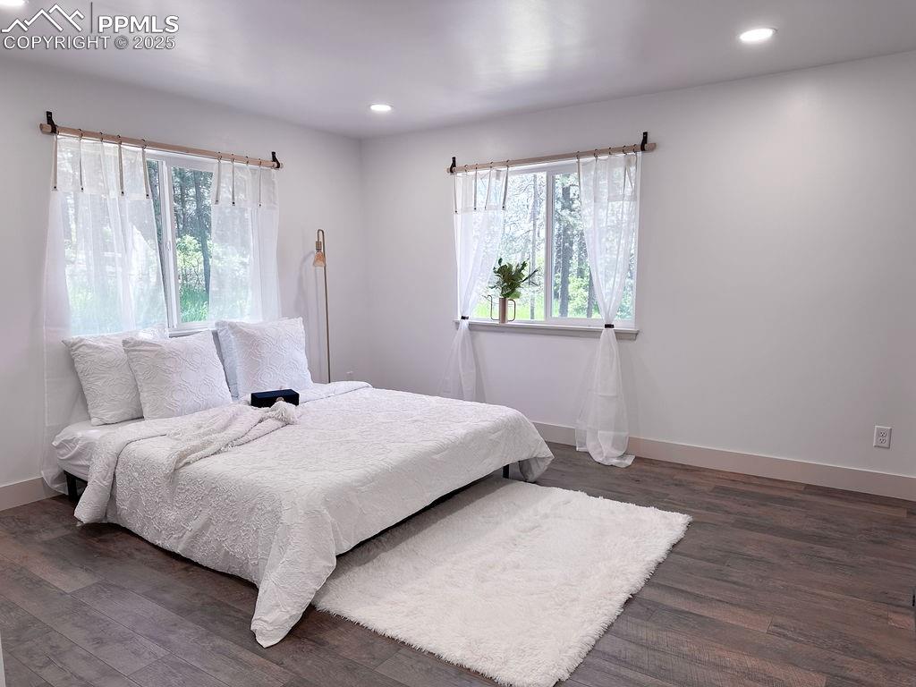 14546 Pine View Road Larkspur, CO 80118 - Photo 16 of 37 Bedroom with multiple windows, dark wood-type flooring, and recessed lighting