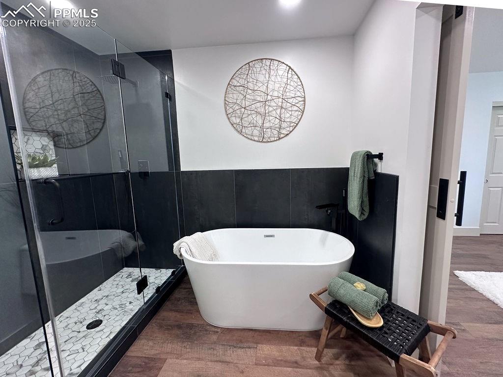14546 Pine View Road Larkspur, CO 80118 - Photo 17 of 37 Bathroom with a soaking tub, wood finished floors, and a stall shower