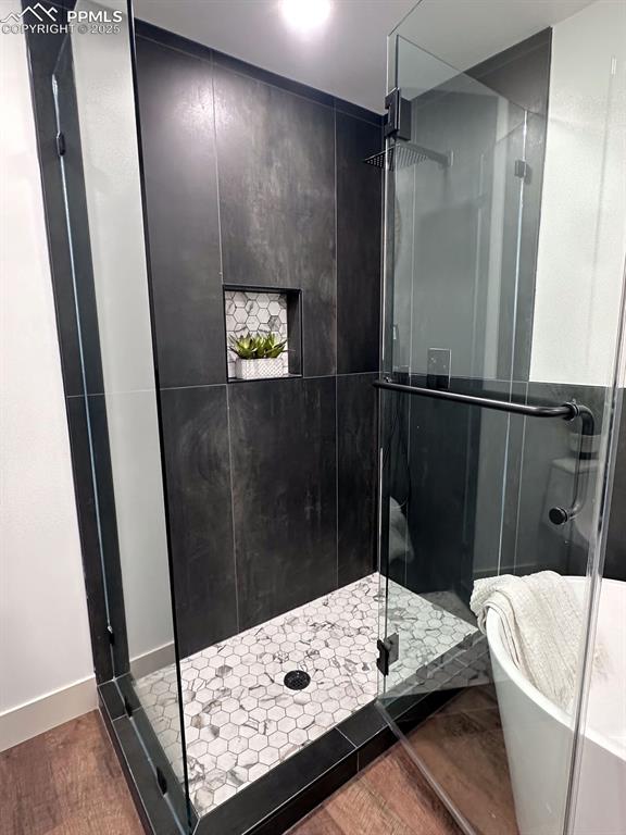 14546 Pine View Road Larkspur, CO 80118 - Photo 20 of 37 Bathroom featuring a shower stall, wood finished floors, and a soaking tub