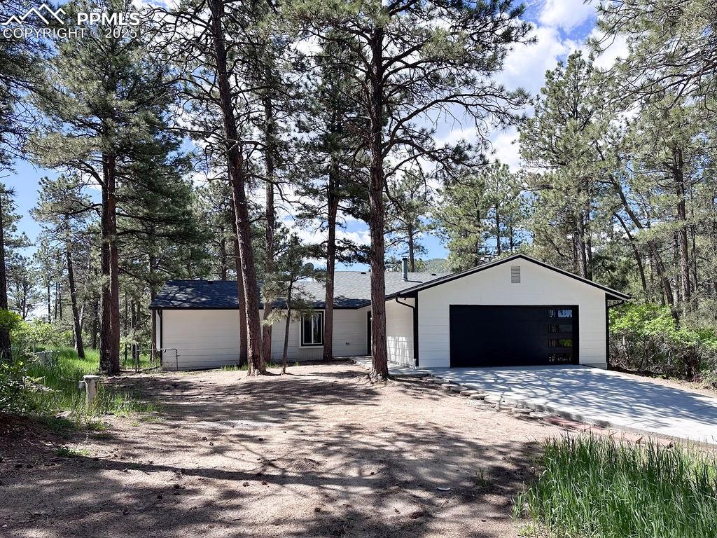 14546 Pine View Road Larkspur, CO 80118 - Photo 2 of 37 View of front facade featuring concrete driveway and a garage