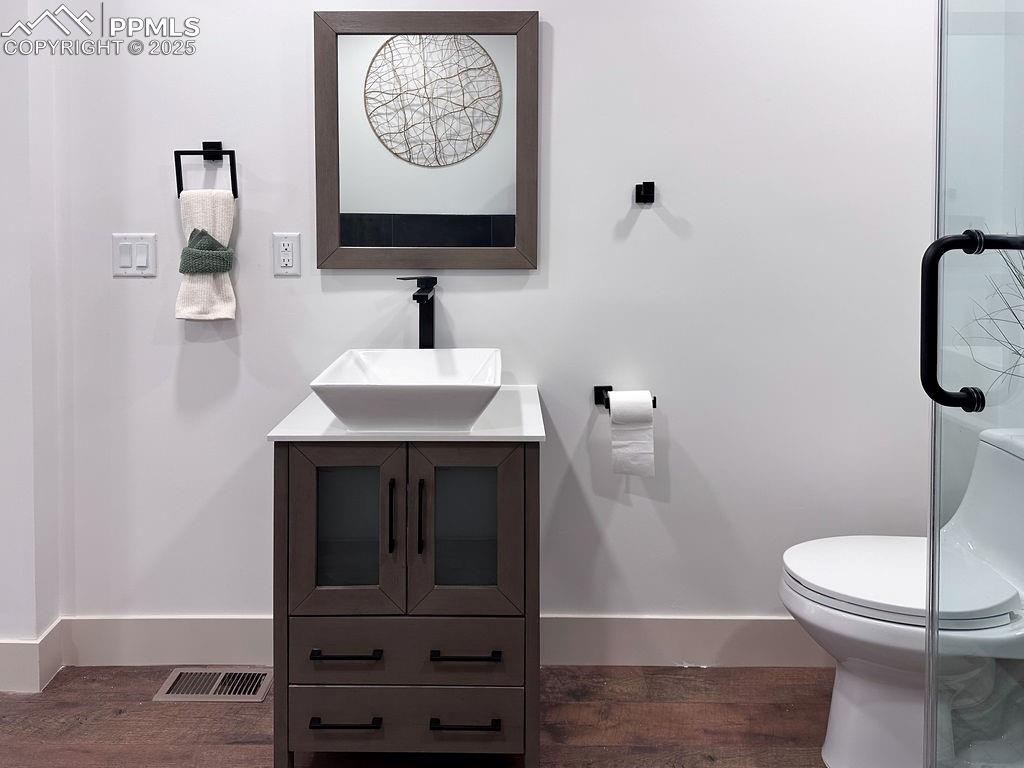 14546 Pine View Road Larkspur, CO 80118 - Photo 21 of 37 Bathroom featuring wood finished floors and vanity