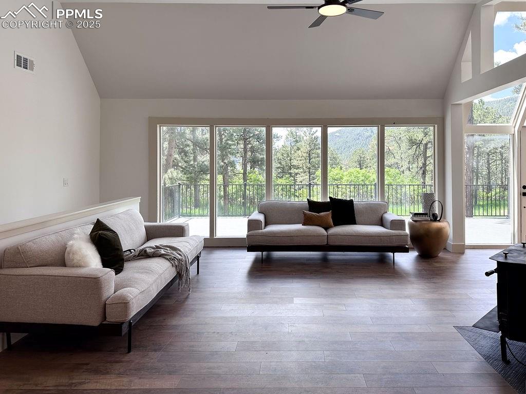 14546 Pine View Road Larkspur, CO 80118 - Photo 9 of 37 Living room with high vaulted ceiling, a ceiling fan, and wood finished floors