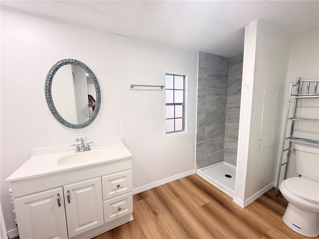 26352 Mc Allister Street Brooksville, FL 34602 - Photo 14 of 26 a bathroom with a sink a toilet and shower