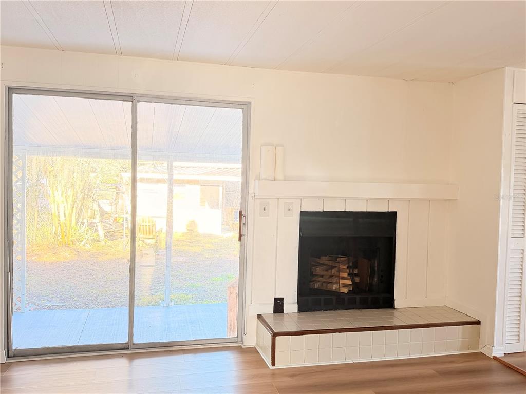 26352 Mc Allister Street Brooksville, FL 34602 - Photo 24 of 26 a living room with a fireplace and a glass door