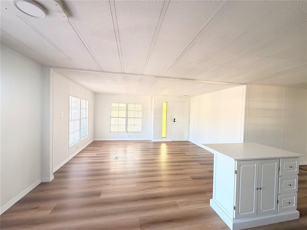 26352 Mc Allister Street Brooksville, FL 34602 - Photo 6 of 26 a view of an empty room with window and wooden floor