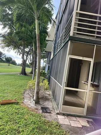 a view of backyard with wooden fence and a large tree