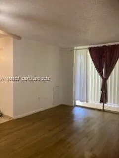 a view of a room with wooden floor and window