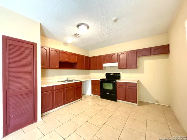 a large kitchen with a stove a sink dishwasher and a refrigerator