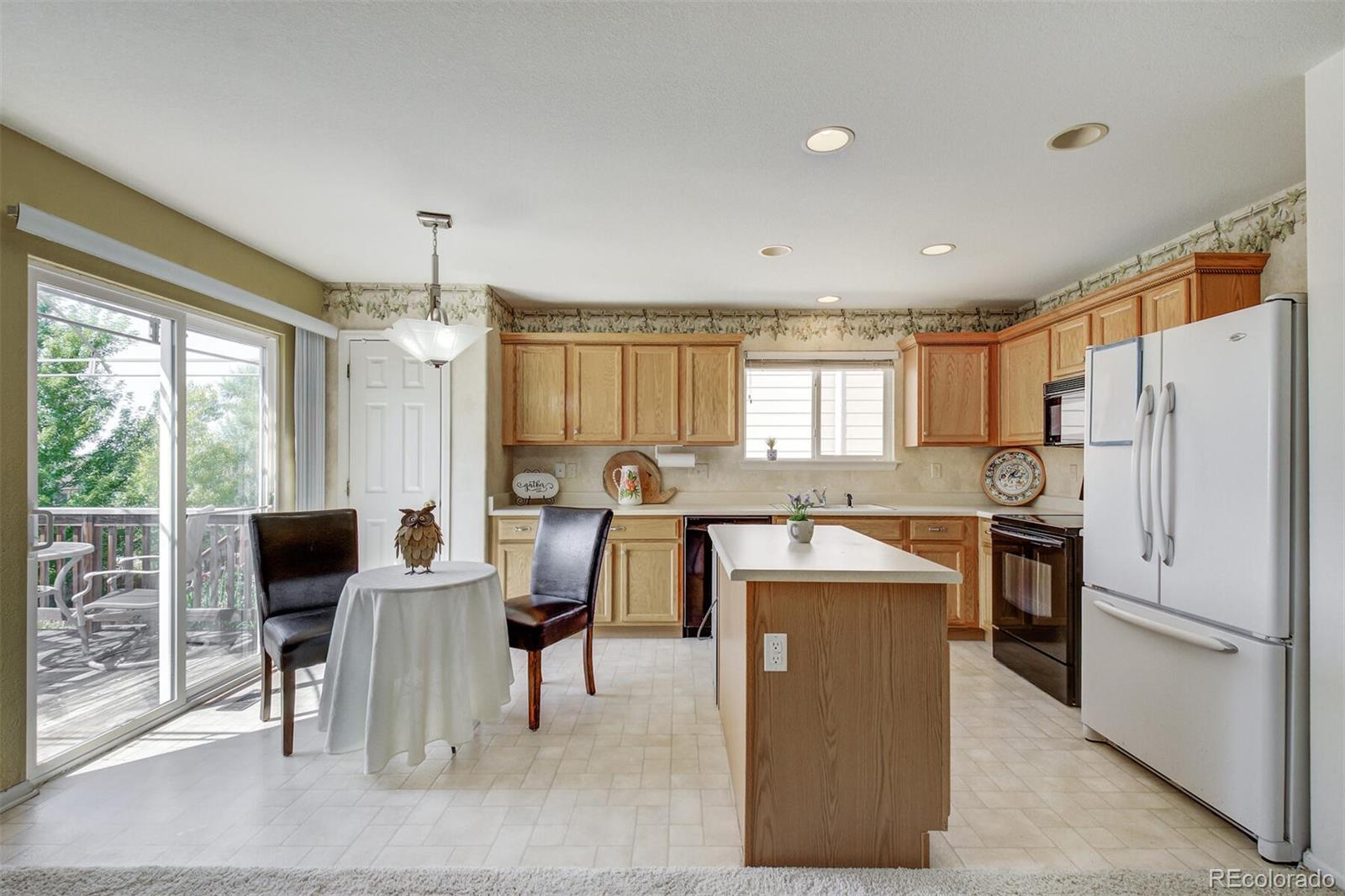 5555 South Rome Street Aurora, CO 80015 - Photo 12 of 34 a large kitchen with a table and chairs
