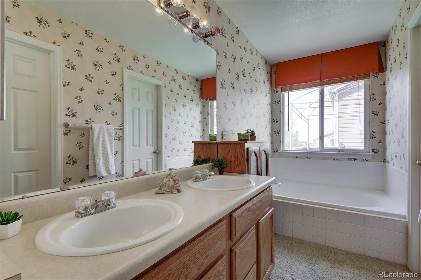 5555 South Rome Street Aurora, CO 80015 - Photo 22 of 34 a bathroom with a tub sink and mirror