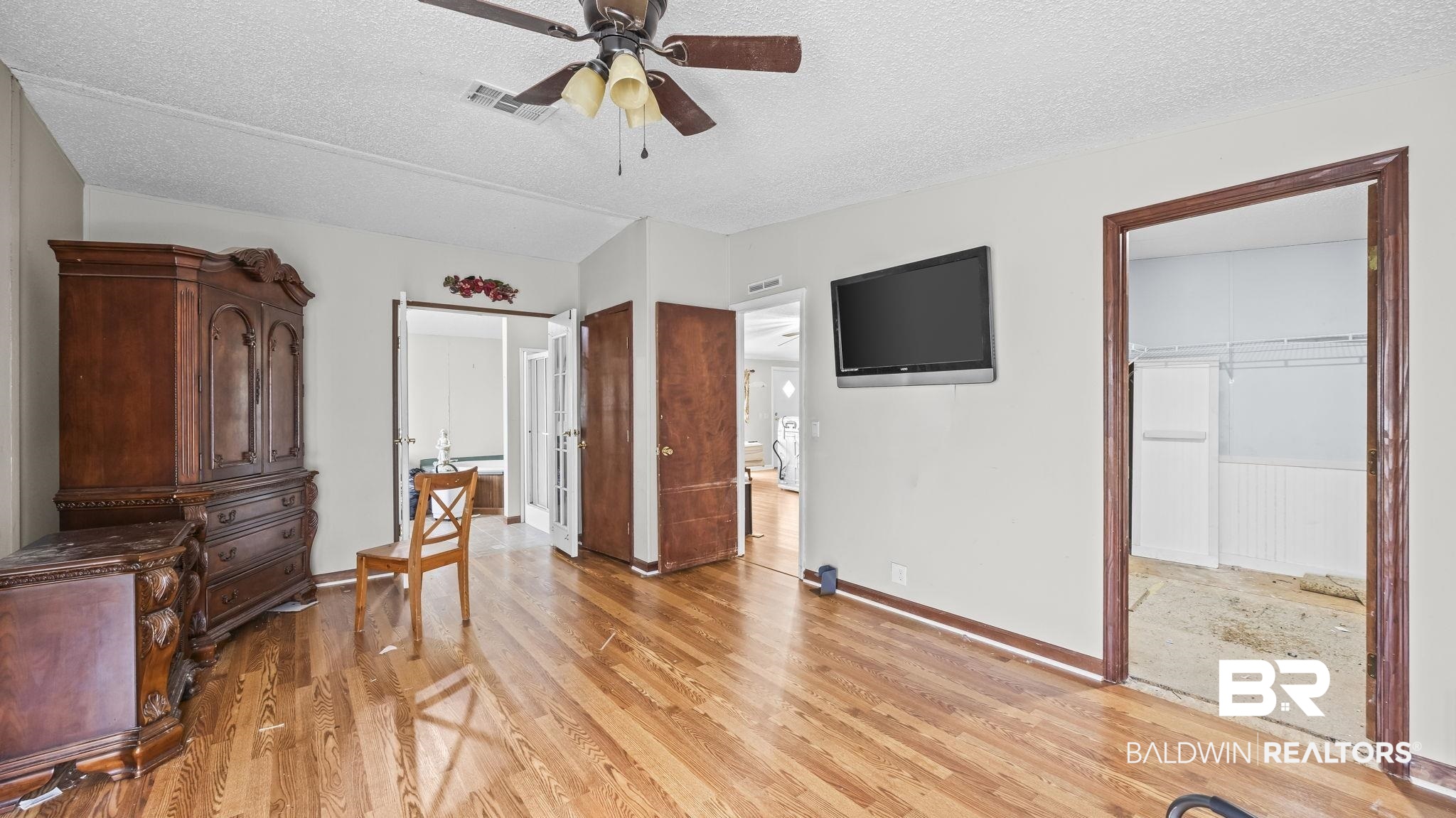 34985b Spring Road South, Unit B Stapleton, AL 36578 - Photo 22 of 31 Wood-finish flooring throughout, featuring a ceiling fan with integrated lighting, white walls, and dark wood trim