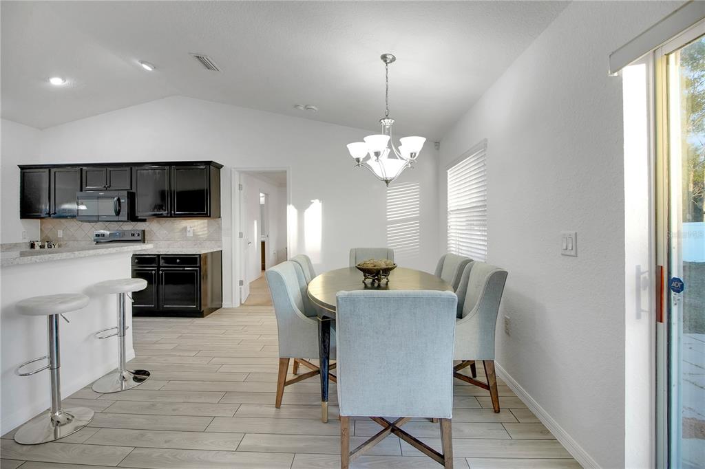 314 Stone Castle Loop Lady Lake, FL 32159 - Photo 11 of 42 a view of a dining room with furniture a fireplace and chandelier