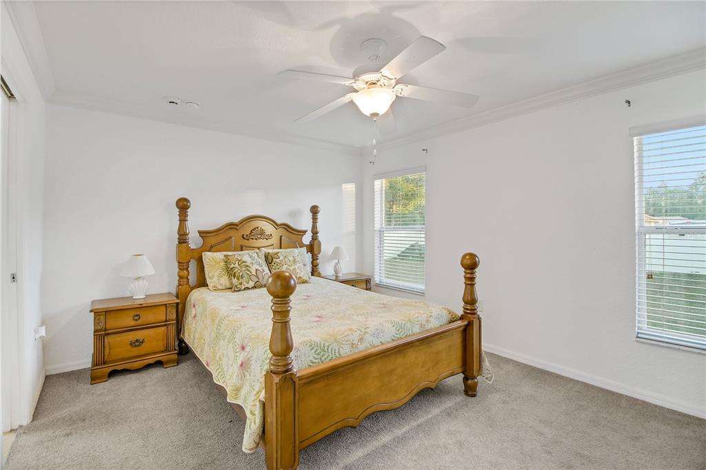 314 Stone Castle Loop Lady Lake, FL 32159 - Photo 26 of 42 a bedroom with a bed and a chandelier