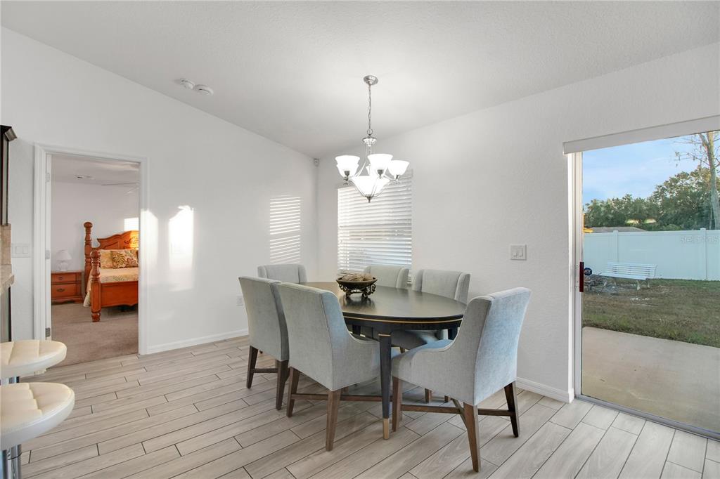314 Stone Castle Loop Lady Lake, FL 32159 - Photo 27 of 42 a dining room with furniture and wooden floor
