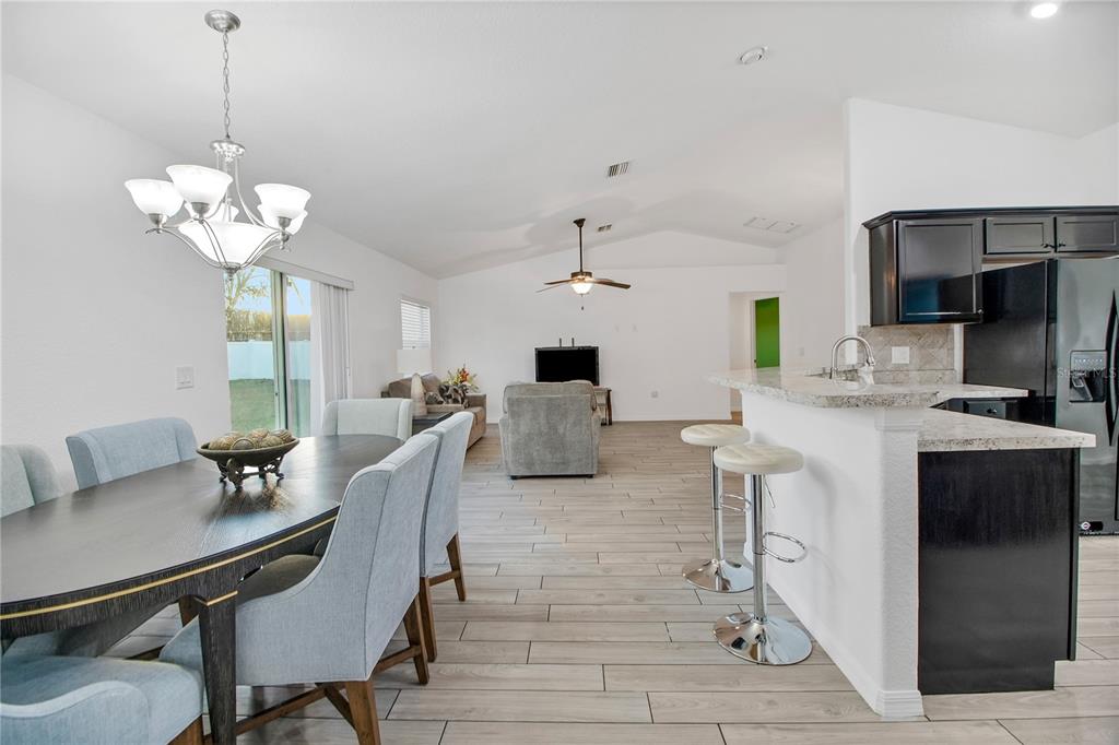 314 Stone Castle Loop Lady Lake, FL 32159 - Photo 39 of 42 a view of a dining room with furniture wooden floor and chandelier