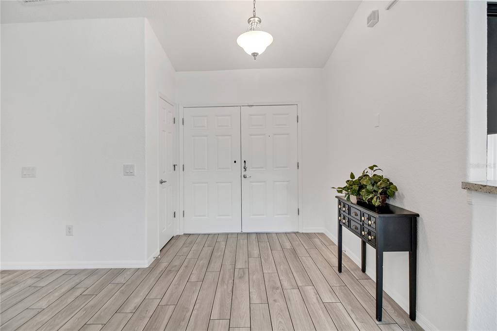 314 Stone Castle Loop Lady Lake, FL 32159 - Photo 7 of 42 a view of a room with wooden floor and potted plant